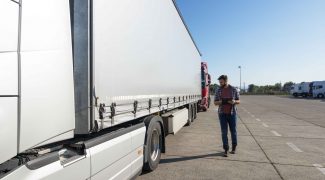 truck driver inspecting vehicle trailer tires before driving